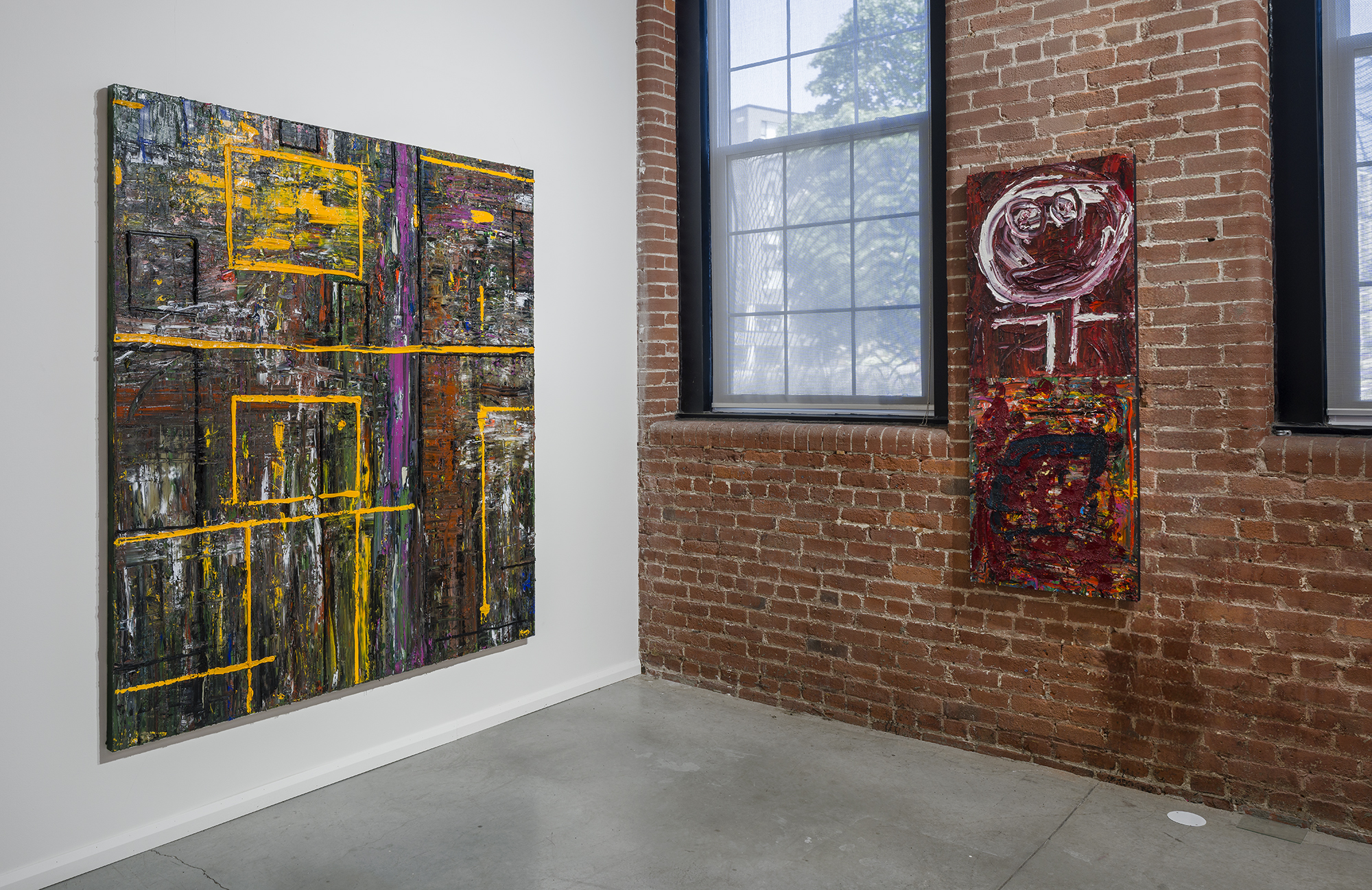 A’yin Morradi in the gallery with one of the large yellow-framed canvases